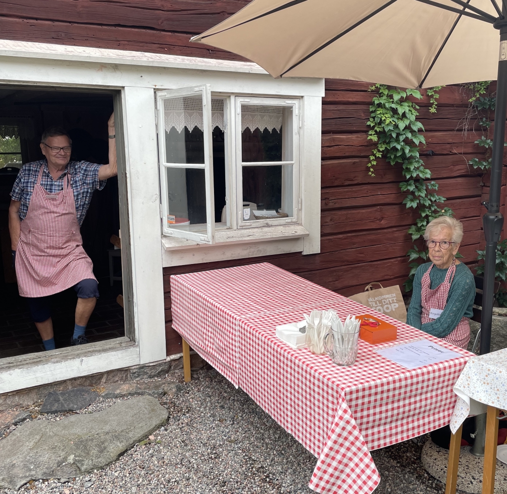 Anders och Birgitta avvaktar ko&#776;n av va&#778;ffelga&#776;ster vid bagarstugan