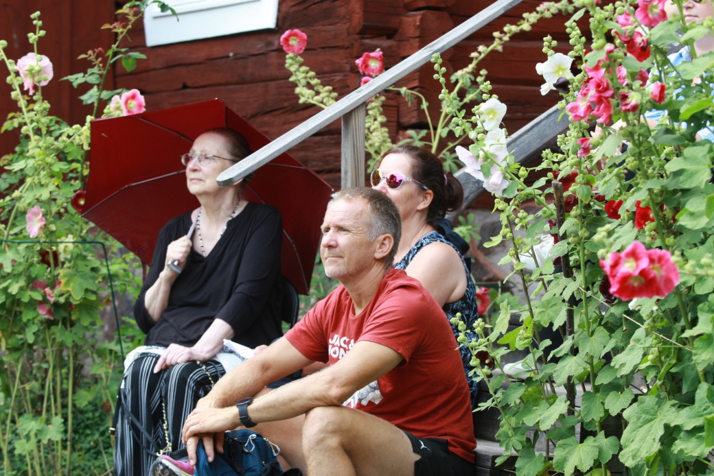 publik a&#776;ven i trappa bland stockrosorna